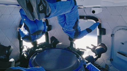 Astronauts look out of the windows and float inside the capsule