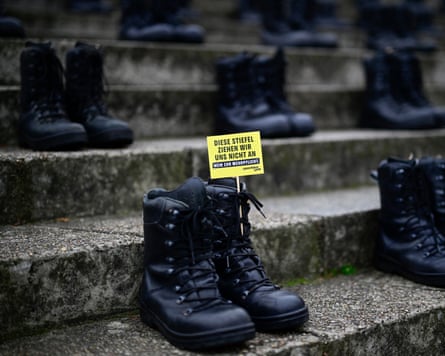 A note reads ‘We’re not putting on those boots’ on one of about 150 boots placed on the steps of the Reichstag in Berlin