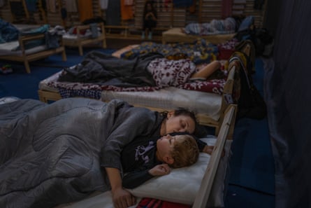 Pengungsi dari Ukraina beristirahat di gym sekolah dasar di Přemysl, yang telah diubah menjadi tempat penampungan sementara bagi para pengungsi.  Sebagian besar pengungsi tinggal di sekolah selama beberapa hari hingga seminggu, sebelum melanjutkan perjalanan untuk berlindung di tempat lain di Uni Eropa.