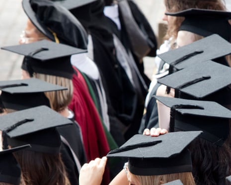 Graduates wearing mortar boards wait to be photographed after a degree ceremony
