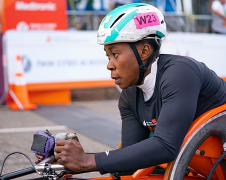 Hannah Babalola in a racing wheelchair on the course, wearing a helmet
