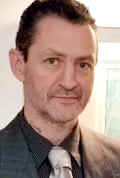 Daniel Coleman. He is in his early 40s with short dark hair slicked back from his face, short stubble and brown eyes, and is dressed smartly in a black pinstripe shirt, dark jacket and silver tie.