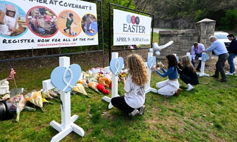 Girls write messages on a memorial for the victims of Monday's school shooting.