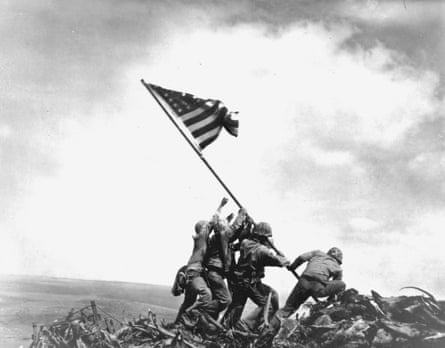 Black and white image of members of the United States Marine Corps 5th Division as they raise an American flag on Mount Suribachi during the Battle of Iwo Jima, February 23, 1945