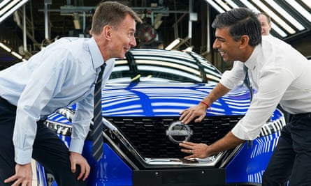 Jeremy Hunt ve Rishi Sunak, Sunderland fabrikasını ziyaretleri sırasında bir arabaya Nissan amblemi iliştiriyorlar.