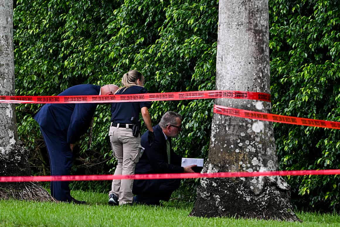 People near hedge and police tape