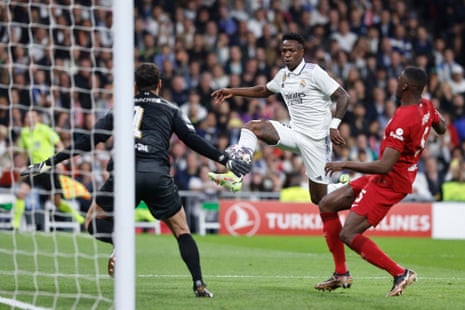 Real Madrid's Vinicius Junior (centre) gets ahead of Liverpool’s Ibrahima Konate (right) as Liverpool’s keeper Alisson Becker prepares to make a save.