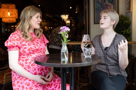 Jo and Ruby sit on high stools at a small restaurant table, chatting
