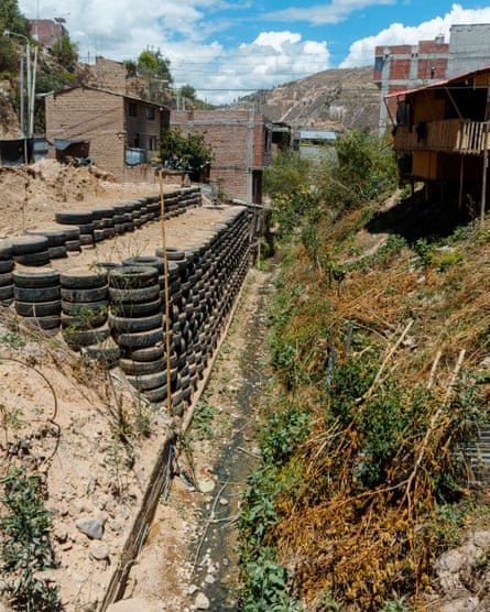 Houses built on the sides of a steep slope. Tyres have been piled up to level the land.