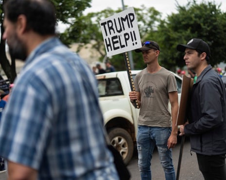 two men wearing hats hold signs