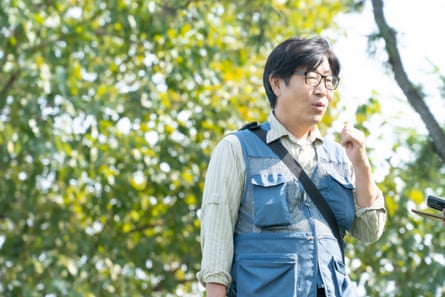 A Korean man with glasses and a shirt and gilet