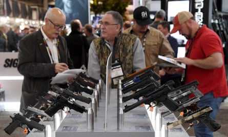 Convention attendees look at handguns at the Browning booth at the 2018 National Shooting Sports Foundation Outdoor Shooting and Hunting Trade Show in Las Vegas, Nevada.