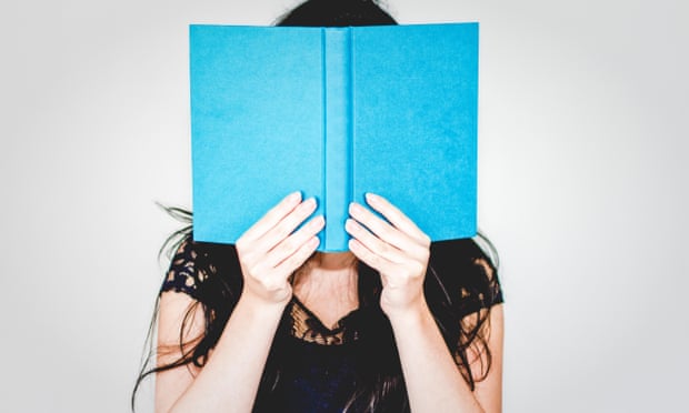 Woman hiding behind book