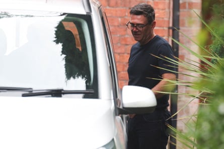 Andy Burnham stands next to a car on his driveway