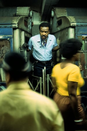 a Willy Spiller photo titled "Conductor Between Subway Cars, 1977-1985" – a male train conductor stands between two subway carriages as passengers walk past on the platform in front of him