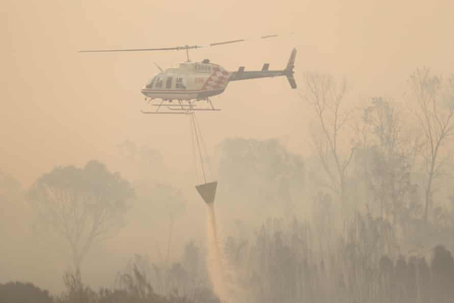 Water bombing helicopters refilling in a farm dam.