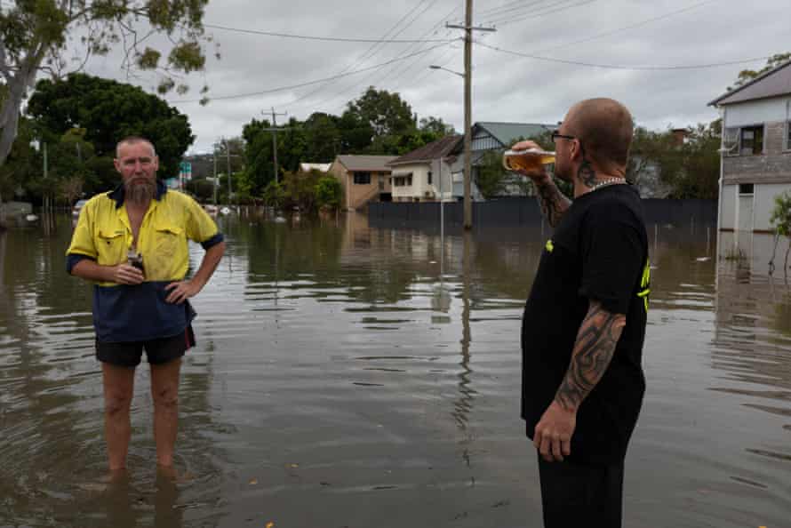Neighbours Steve Miller (left) and Matt Lewis stand in the receding flood waters in Lismore