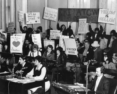 Demonstrators hold up their signs in support of the Holy Redeemer Catholic school in Chinatown during city council hearings in Philadelphia’s city hall. Lynne M. Abraham and James Martin (bottom left, sitting at the table) testify.