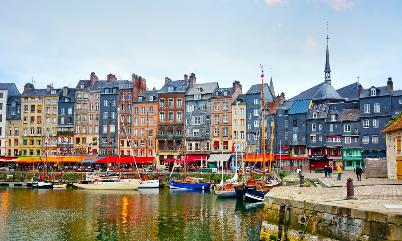 Honfleur harbour and a background of tall, colourful houses in Normandy.