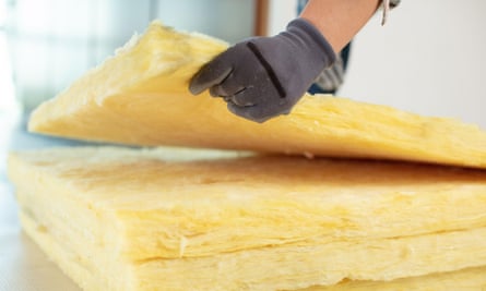 a worker lays loft insulation