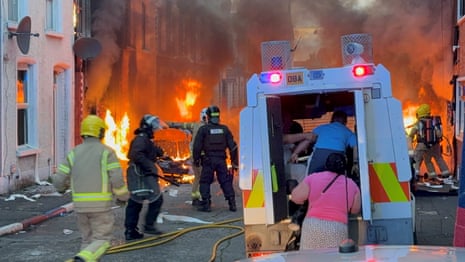A family get into a PSNI vehicle after being rescued from houses which caught fire in Lendrick Street in east Belfast.