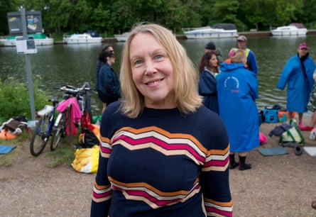 Marlene Lawrence smiles as she stands near a group of people by the river