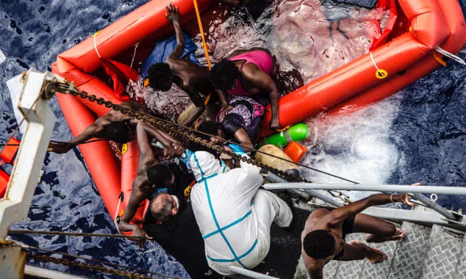 Rescuers help migrants to board the Italian Navy ship Vega, after the boat their boat sunk. 