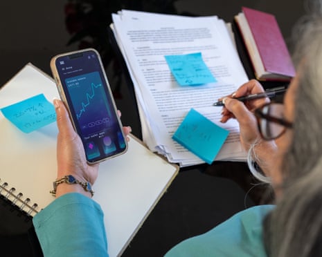 Over-the-shoulder shot of a woman managing her finances using her smartphone