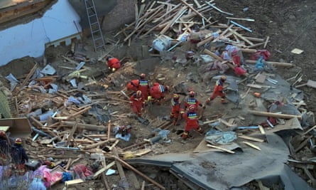 新華社通信が公開したこの航空写真では、中国青海省北西部、海東市の閩和回ウトゥ族自治州カオタン村で倒壊した建物を救助隊員が捜索している。