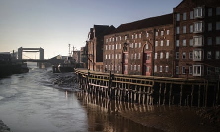 Converted former warehouses along the River Hull, with the tidal barrier in the distance.