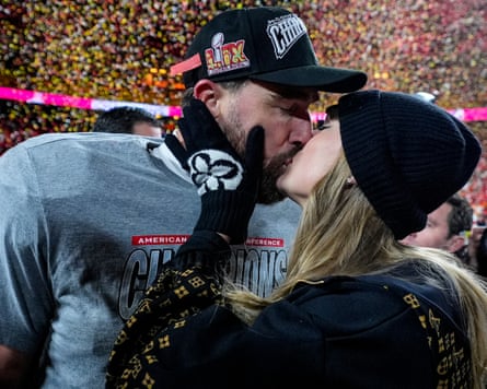 Travis Kelce and Taylor Swift kiss in a stadium