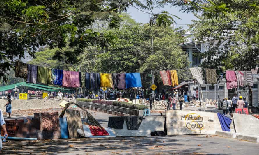 Des manifestants barricadent une route de Yangon avec des femmes longyi.