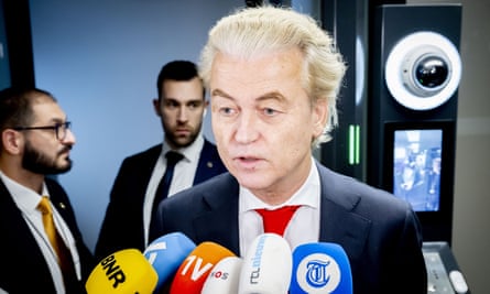Geert Wilders speaking into a multicoloured bunch of microphones being held up to him
