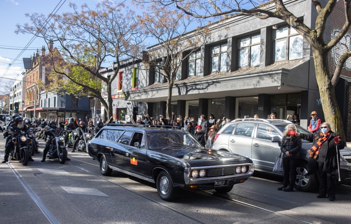 The hearse stands in front of a line of people on Gertrude St