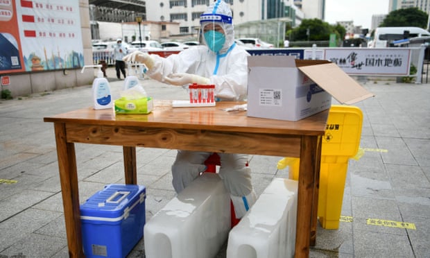 A medical worker sits with ice blocks at a Covid testing site amid a heat wave warning in Nanchang, Jiangxi province