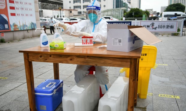 A medical worker sits with ice blocks at a Covid testing site amid a heatwave warning in Nanchang, Jiangxi province