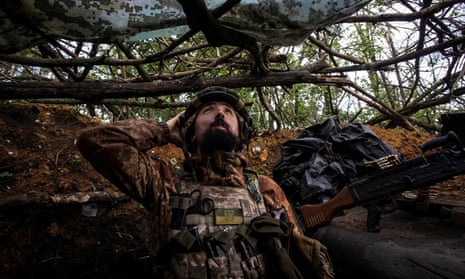 A Ukrainian soldier in a trench, watching for a possible drone attack, Donetsk region.