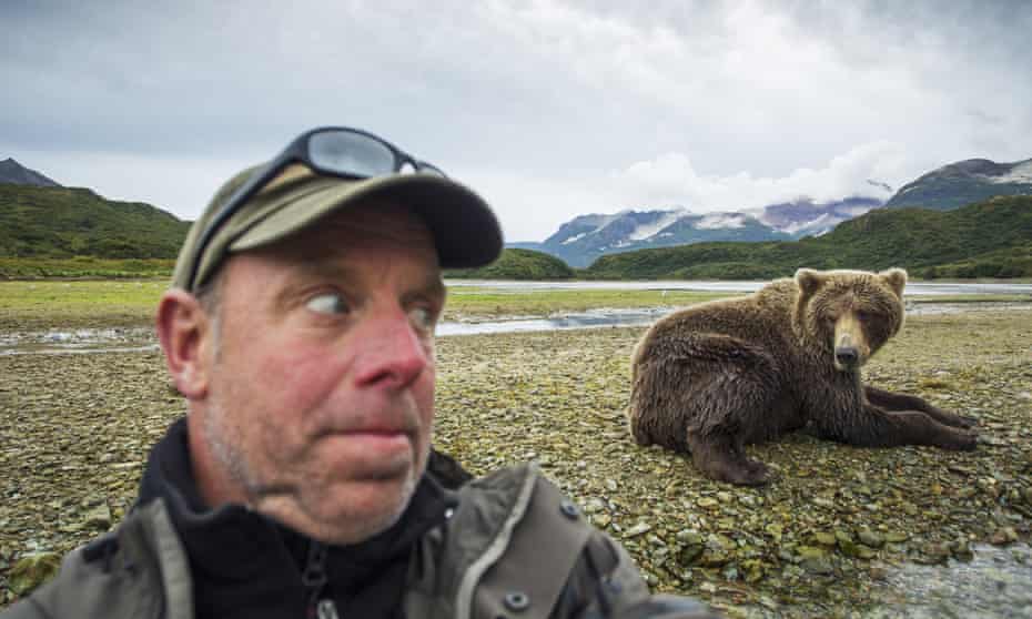 The American photographer Paul Souders takes a selfie with a grizzly bear near a salmon spawning stream in Katmai National Park, Alaska.