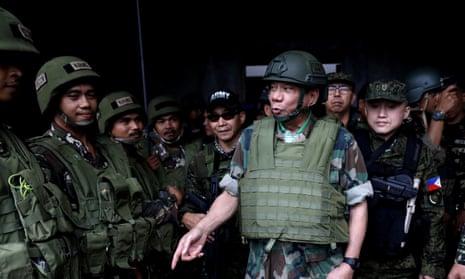 The Philippine president, Rodrigo Duterte, in a bulletproof vest and helmet as he speaks to troops fighting in Marawi in August