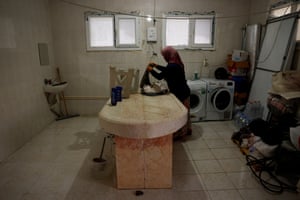 Hatice Dogru, 43, prepares to do laundry in one of the rooms in the morgue used to wash bodies, in Cankaya cemetery