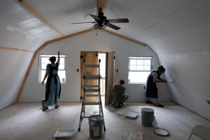 People painting the interior of a cabin