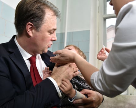Igor Pereginets holds a child during a polio vaccination in Kiev on 21 October 2015.