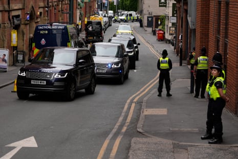 Police convoy with officers lining the street.