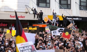 Protesters with Aboriginal flag in Sydney