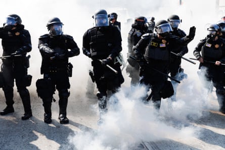 law enforcement in tactical gear walk through smoke
