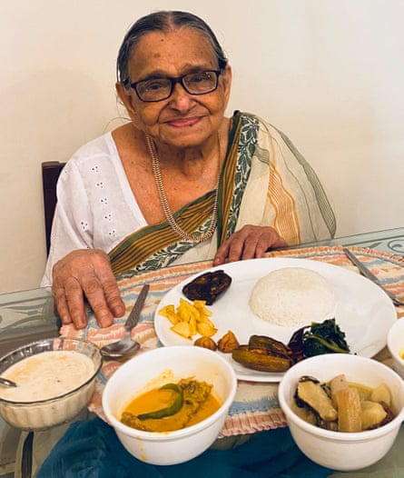 La grand-mère d'Anindita Ghose, Didu, avec plusieurs plats devant elle.