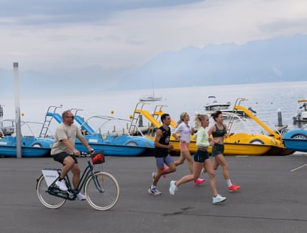 Trevor Painter follows athletes Keely Hodgkinson and Georgia Hunter-Bell, Catriona Bisset and Ethan Massey during a training run in Lausanne.