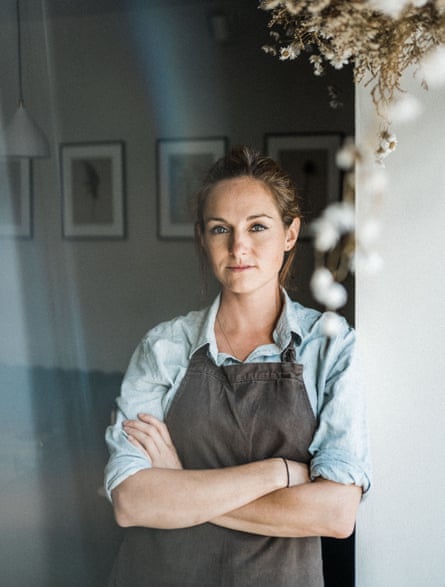 A woman in an apron poses.