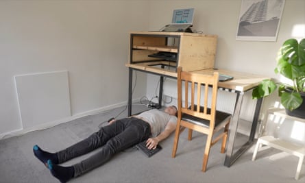 A man using a lying-down computer table