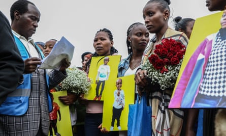 Mourners hold portraits of their loved ones during a prayer and mass funeral service for those who died in the Maai Mahiu floods.